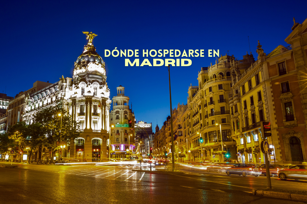 City street at night with illuminated buildings and text 'Dónde hospedarse en Madrid'.